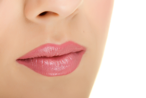 Closeup of a woman's pink lips with a beautiful soft skin.